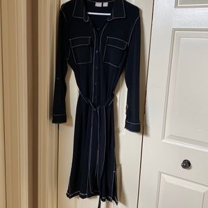 Black polyester below the knee dress with white stitching detail.  Button down.